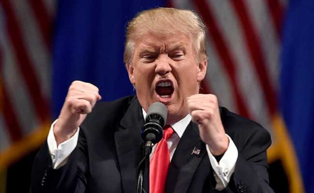 O presidente dos Estados Unidos, Donald Trump, falando com expressão de raiva e apertando as mãos