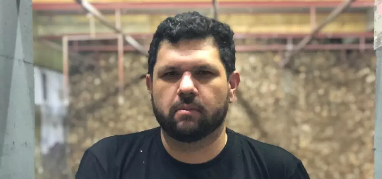 blogueiro Oswaldo Eustáquio Filho de camiseta preta, olhando pra câmera, sério