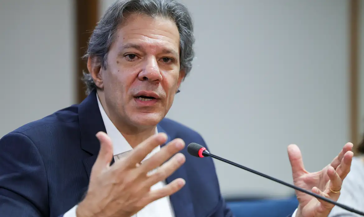 ministro da Fazenda, Fernando Haddad, falando e gesticulando, sério