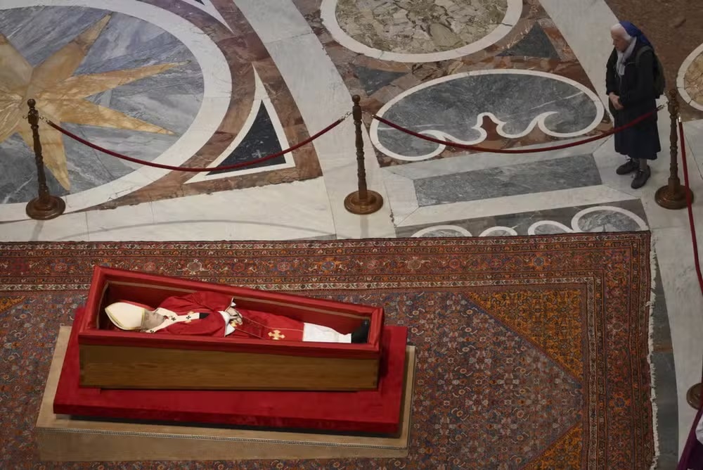 Freira Geneviève Jeanningros em pé, próxima do caixão do papa Francisco