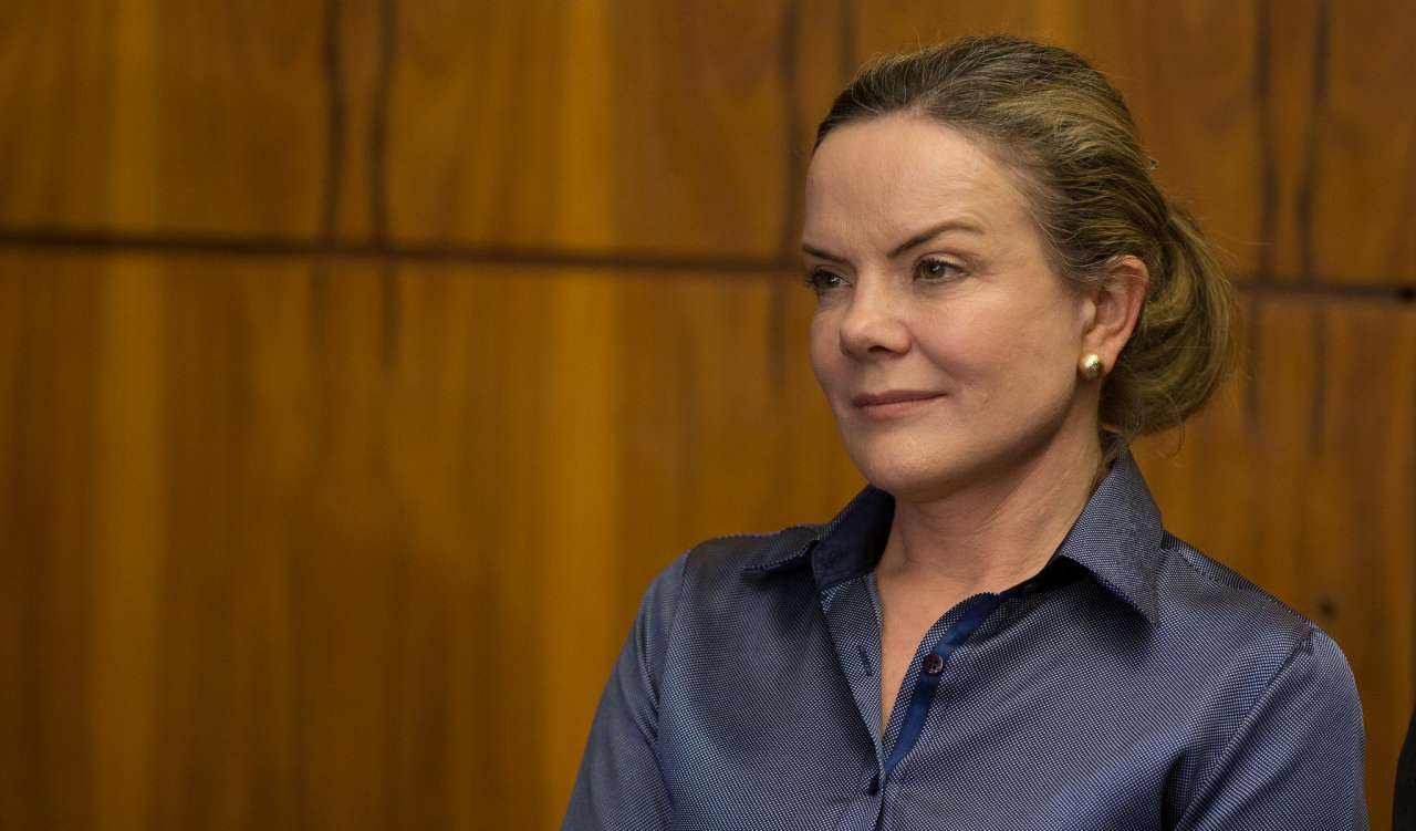 A ministra das Relações Institucionais, Gleisi Hoffmann, de cabelo preso, com expressão confiante, sem olhar para a câmera, de camisa azul escuro