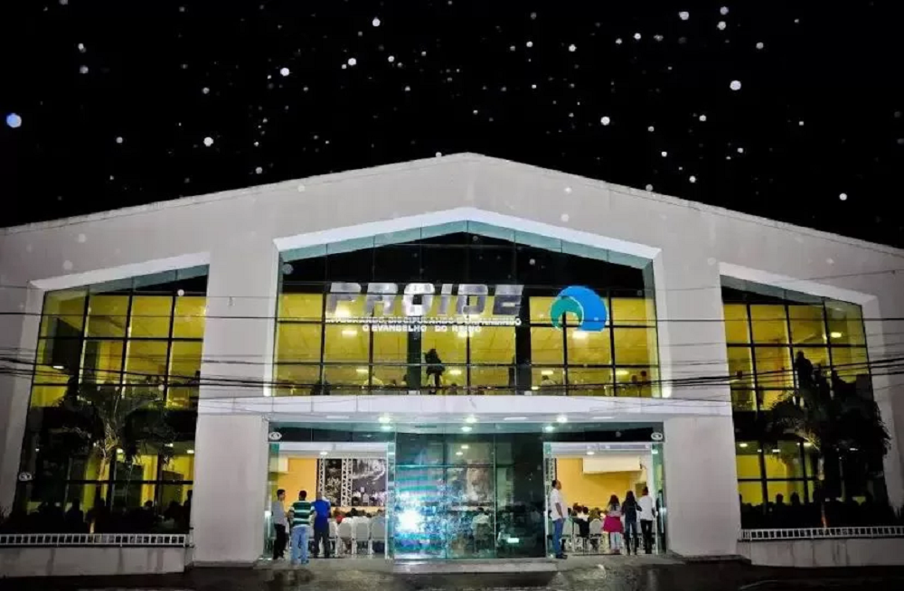 Igreja Projeto IDE (PROIDE), em Cabo Frio, em foto feita à noite, fachada da instituição, com pessoas na frente