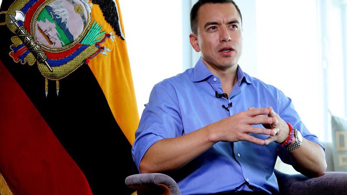 presidente reeleito do Equador, Daniel Noboa, sentado, de roupa social azul, falando e gesticulando