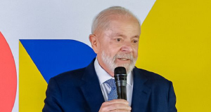 O presidente Luiz Inácio Lula da Silva de terno e gravata, falando em microfone, sem olhar para a câmera