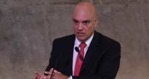 ministro Alexandre de Moraes falando em microfone e gesticulando, sério