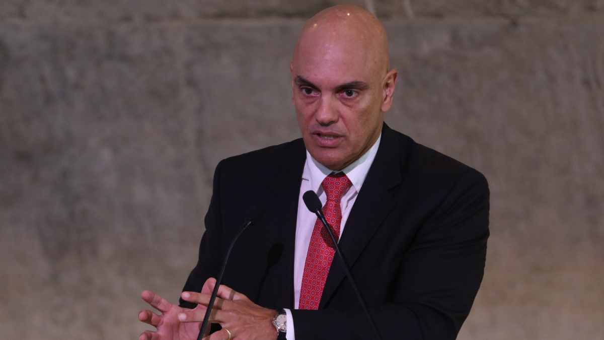 ministro Alexandre de Moraes falando em microfone e gesticulando, sério