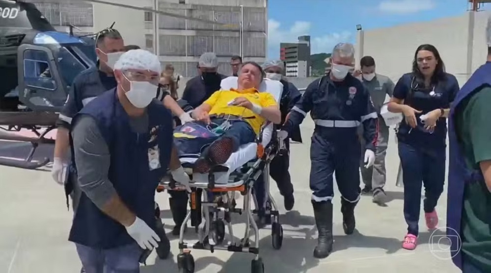 O ex-presidente Jair Bolsonaro (PL) sendo socorrido, deitado em maca