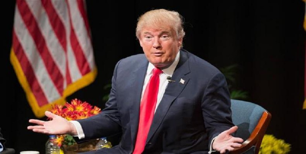 presidente dos EUA, Donald Trump, com os braços abertos e expressão de desafio