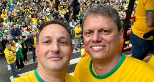 Guilherme Derrite e Tarcísio de Freitas sorrindo para foto, com camisetas amarelas e verdes os dois