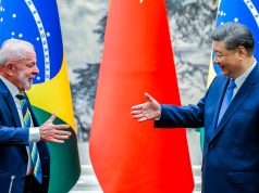 presidente do Brasil, Lula, e o presidente da China, Xi Jinping, se olhando, sorrindo, se preparando para aperto de mãos