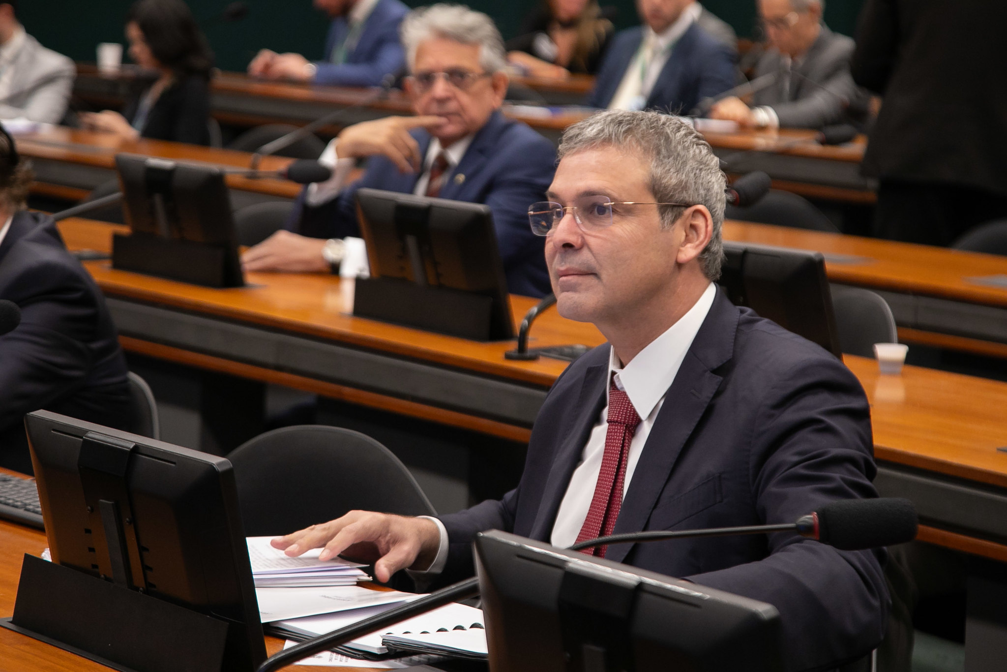 Lindbergh Farias sério, de óculos, olhando pra frente, sentado no plenário da Câmara dos Deputados