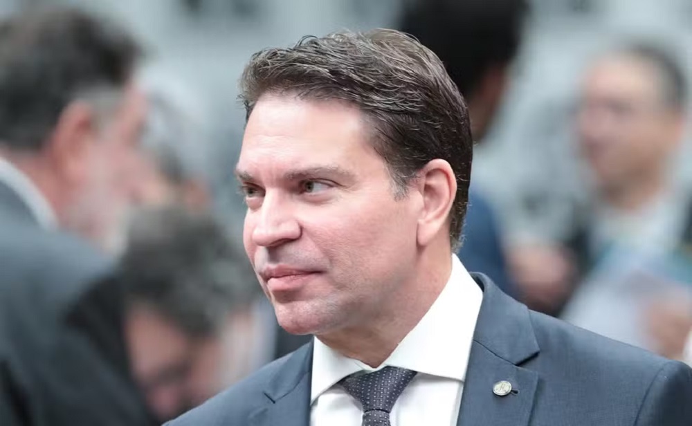 deputado Delegado Ramagem (PL-RJ) de terno e gravata cinza, com camisa social branca, olhando para o lado com expressão confiante