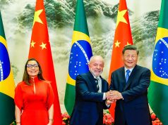 Janja em pé sorrindo e Lula em aperto de mãos com Xi Jinping