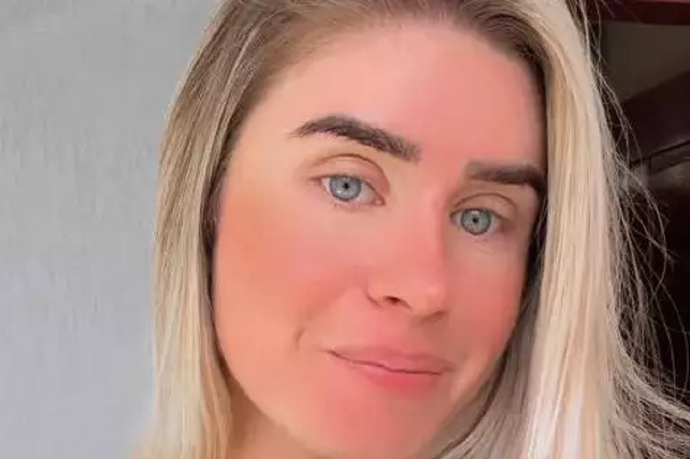 Débora Peixoto em close, séria, olhando para a câmera, de cabelo solto