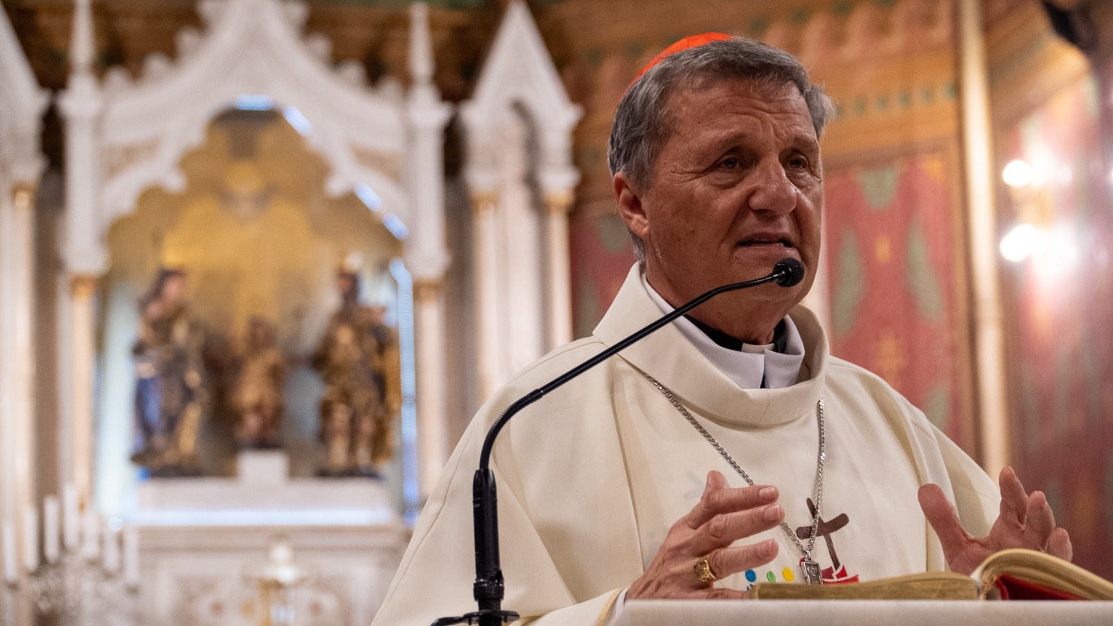 cardeal maltês Mario Grech falando em microfone e gesticulando, sério, sem olhar para a câmera, em igreja
