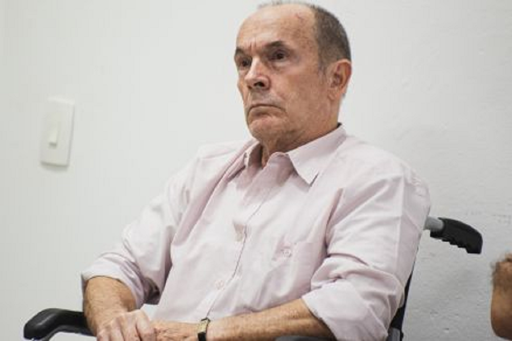 coronel reformado Etevaldo Luiz Caçadini de Vargas sério, sentado em cadeira de rodas, sem olhar para a câmera, com camisa social clara