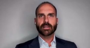 deputado federal licenciado Eduardo Bolsonaro (PL-SP) falando, sério, de fones de ouvido brancos