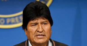 ex-presidente Evo Morales olhando para o lado de rabo de olho e falando, sério