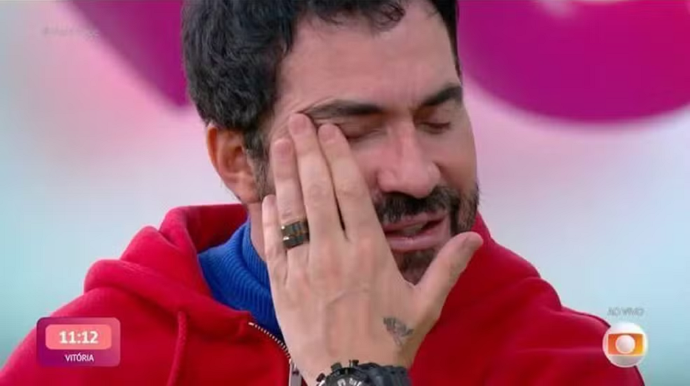 Padre Fábio de Melo chorando, com a mão no rosto