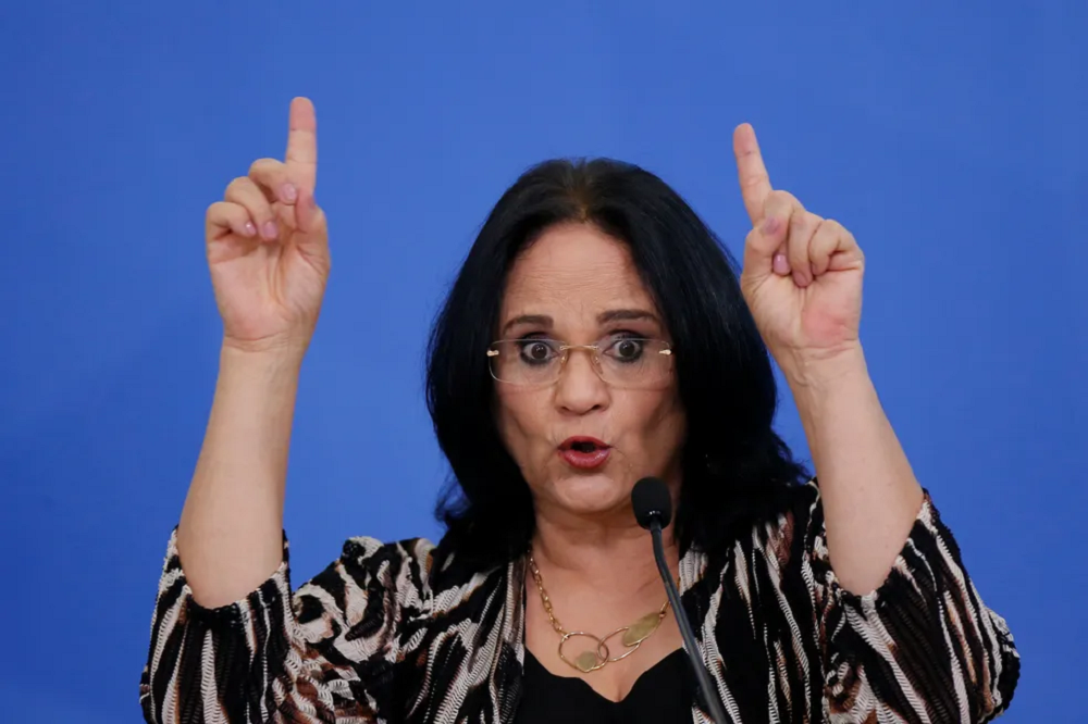 Damares Alves (Republicanos) apontando pra cima, falando em microfone