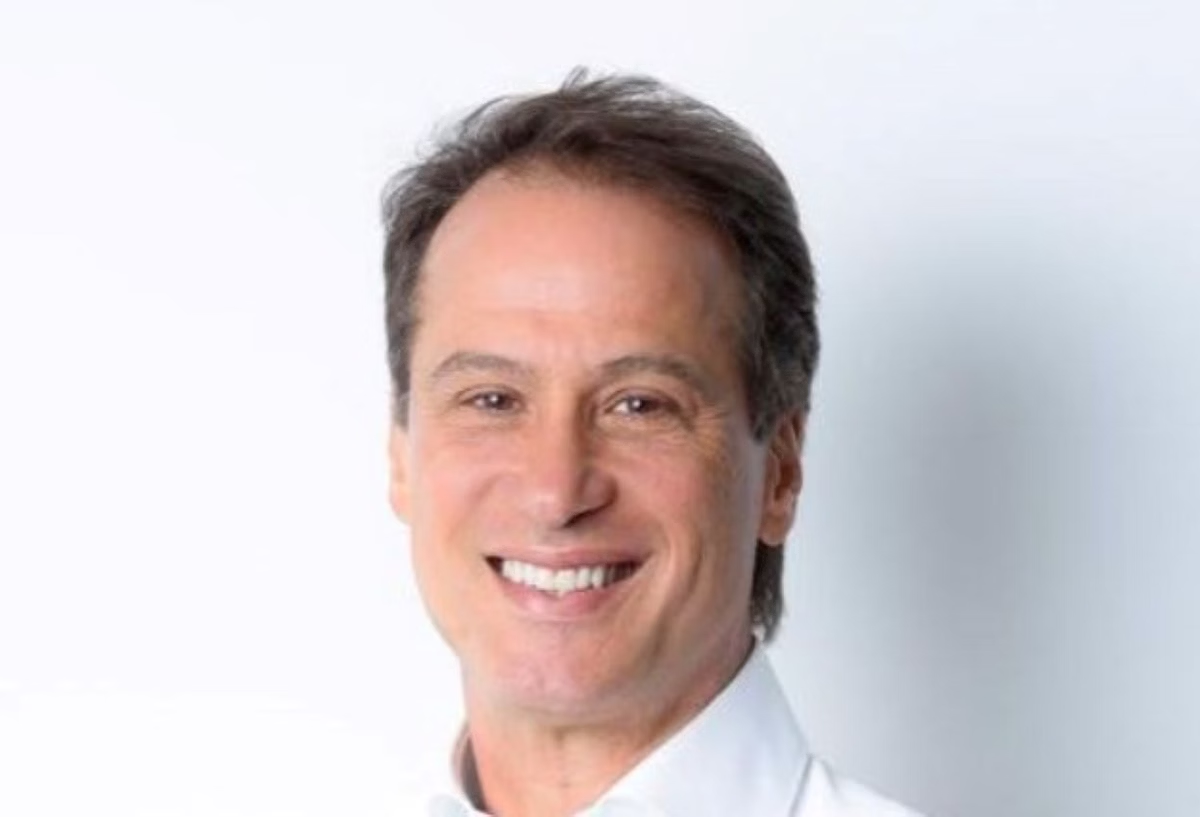 empresário Maurício Camisotti em close, sorrindo para a câmera, de camisa social branca