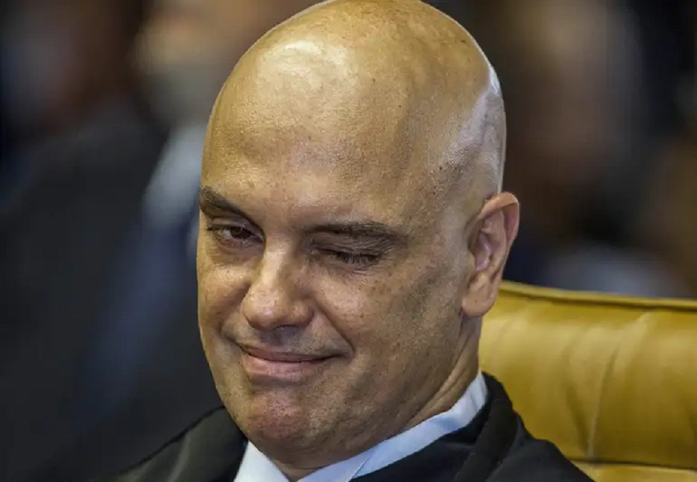 O ministro Alexandre de Moraes, do Supremo Tribunal Federal (STF), piscando e sorrindo levemente, sem olhar para a câmera