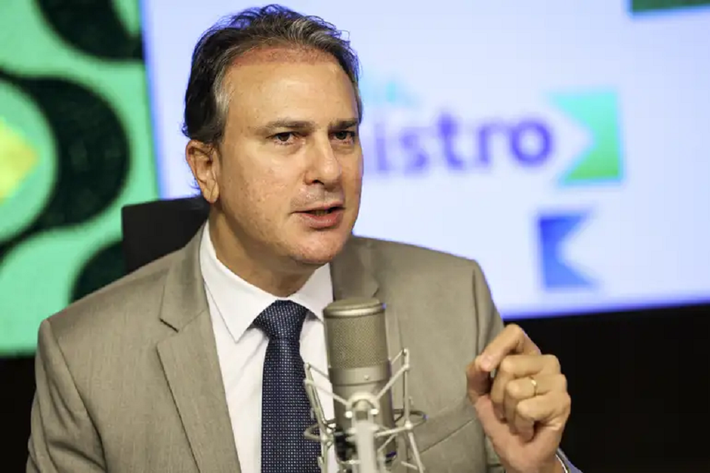 O ministro da Educação, Camilo Santana, falando em microfone, sério, gesticulando, sem olhar para a câmera