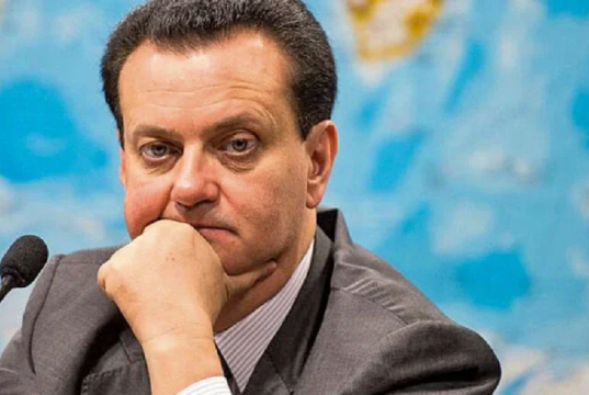 presidente do PSD, Gilberto Kassab, olhando para a câmera, sério, com rosto apoiado em uma das mãos