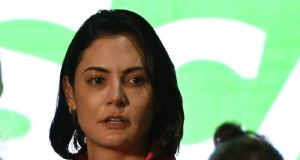 ex-primeira-dama Michelle Bolsonaro em close, com expressão assustada, de cabelo solto, sem olhar para a câmera