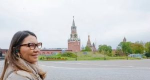 primeira-dama Janja da Silva no canto esquerdo de foto, de perfil, de cabelo solto e óculos de grau, na Rússia