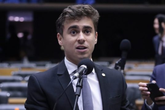 deputado federal Nikolas Ferreira falando em microfone, no plenário