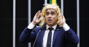 deputado Nikolas Ferreira (PL-MG) de peruca no plenário da Câmara, falando, com as mãos próximas à cabeça