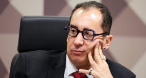senador Jorge Kajuru (PSB-GO) de óculos, olhando para o lado, com o rosto apoiado em uma das mãos e sério