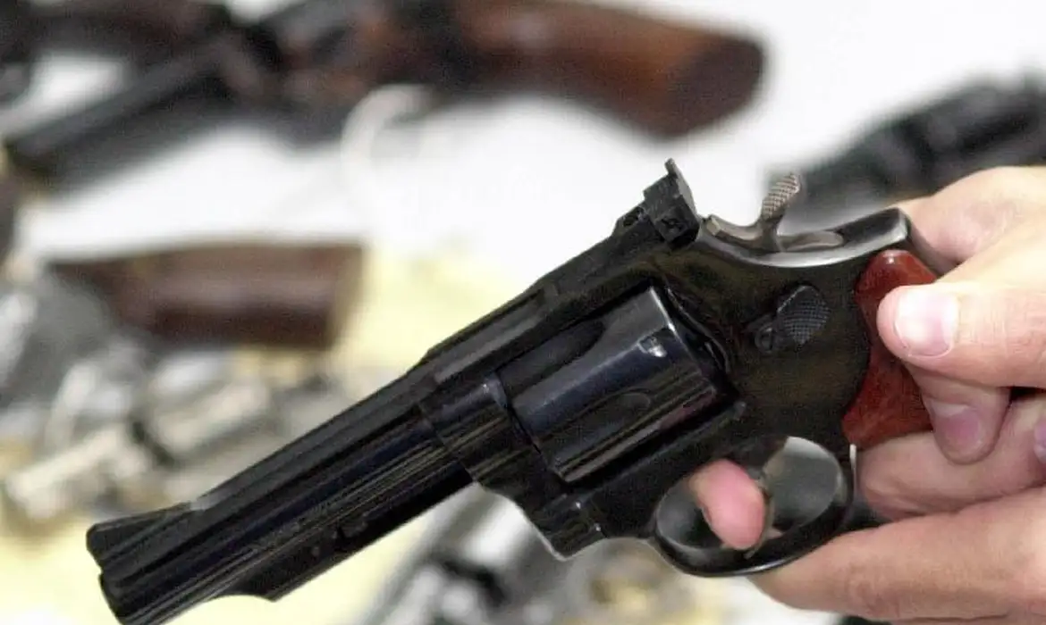 Mão segurando arma