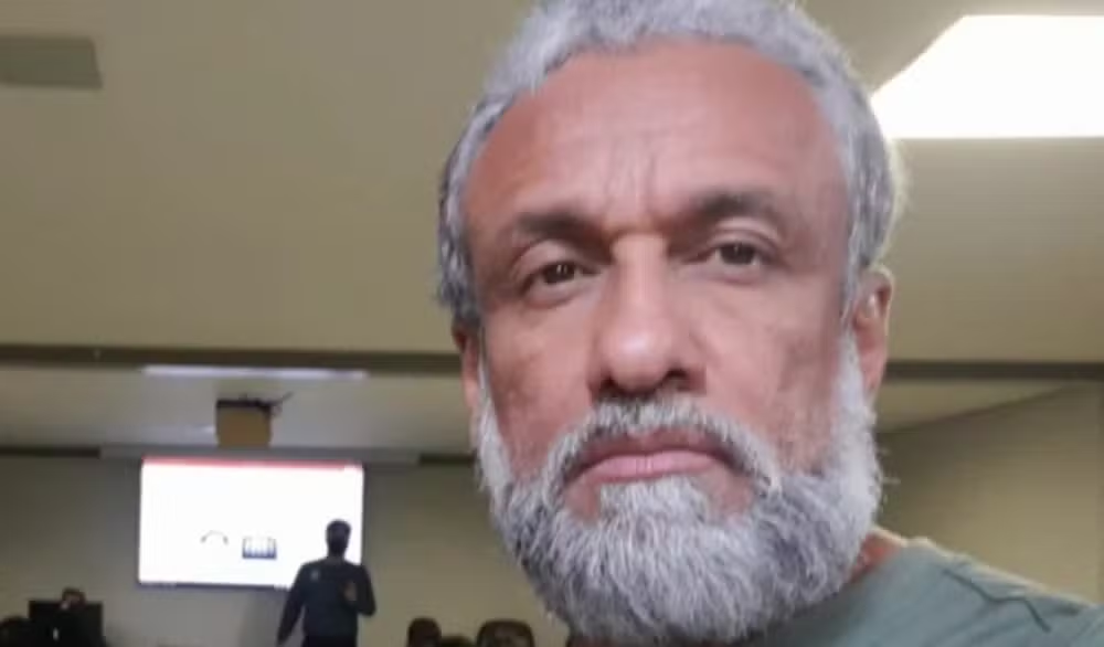 Policial federal Wladimir Matos Soares de camiseta cinza, olhando sério para a câmera, em close