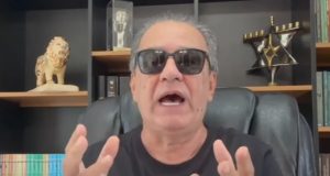 O pastor Silas Malafaia de camiseta preta e óculos escuros, falando e gesticulando