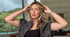 Virginia Fonseca de roupa preta e cabelo solto, com as mãos na cabeça, fazendo carão para a câmera