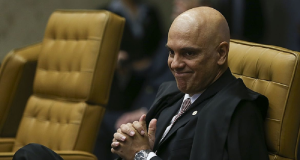 Alexandre de Moraes sorrindo sem olhar para a câmera