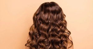 Mulher de costas com cabelo castanho e ondulado aparecendo