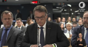 O ex-presidente Jair Bolsonaro (PL) de cabeça baixa e óculos, falando