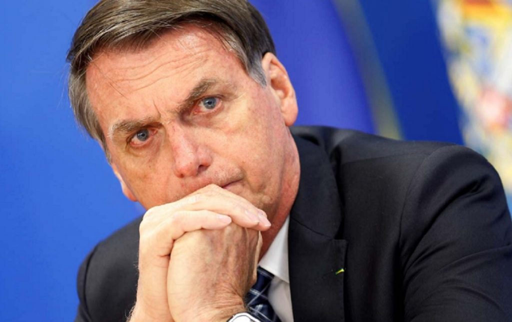 Jair Bolsonaro sério, com expressão pensativa, com rosto apoiado nas mãos