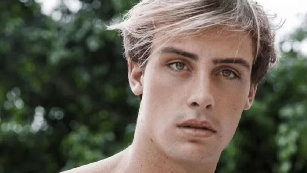 O modelo e influenciador digital Bruno Krupp, em close, sério, olhando para a câmera