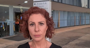 deputada Carla Zambelli (PL-SP) de roupa preta, séria, olhando para a câmera, de cabelo solto