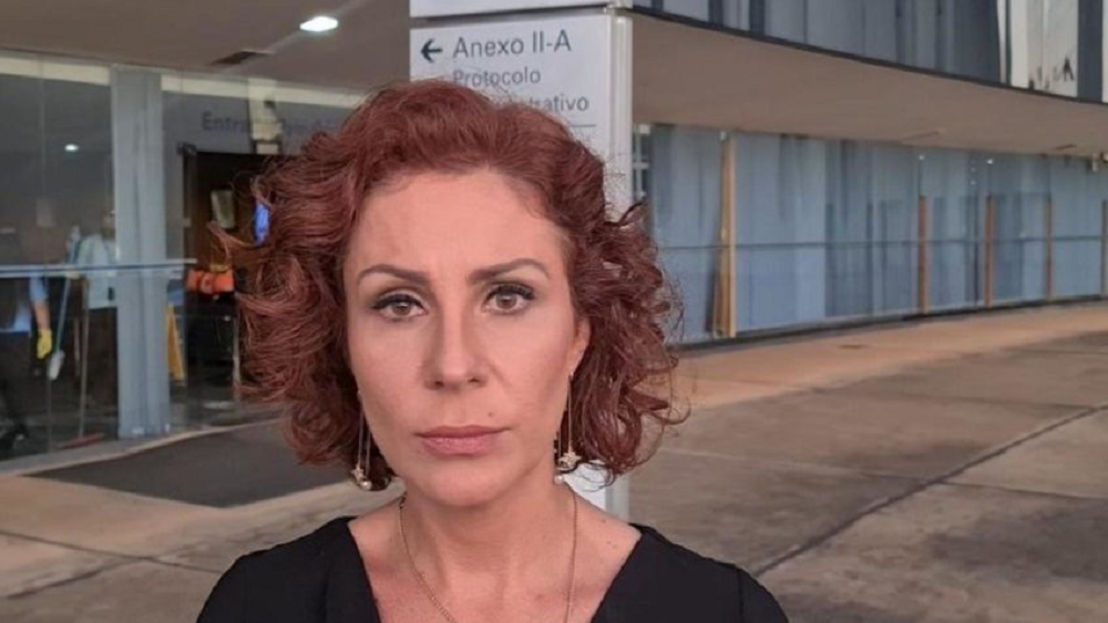 deputada Carla Zambelli (PL-SP) de roupa preta, séria, olhando para a câmera, de cabelo solto