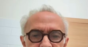 O prefeito de João Pessoa, Cícero Lucena (PP), de camiseta azul e óculos de grau, sério, falando para a câmera