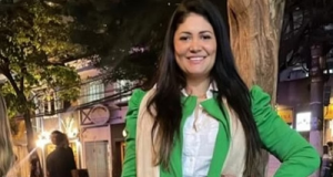 terapeuta Gleici Keli Geraldo de Souza de roupa verde, branca e bege, sorrindo para a câmera com a mão na cintura