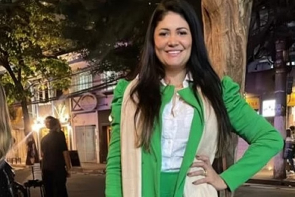 terapeuta Gleici Keli Geraldo de Souza de roupa verde, branca e bege, sorrindo para a câmera com a mão na cintura