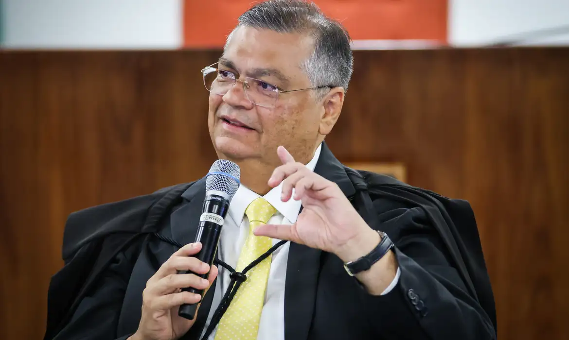 ministro Flávio Dino falando e gesticulando, sem olhar para a câmera