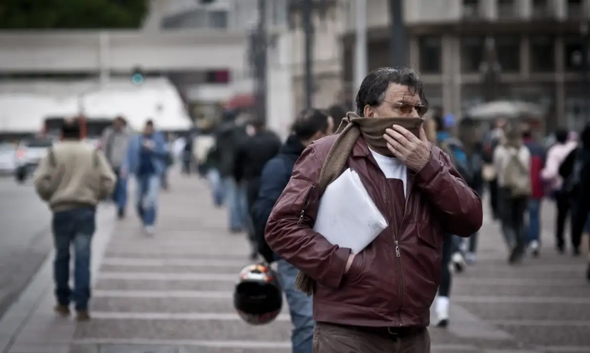 Homem agasalhado andando na rua