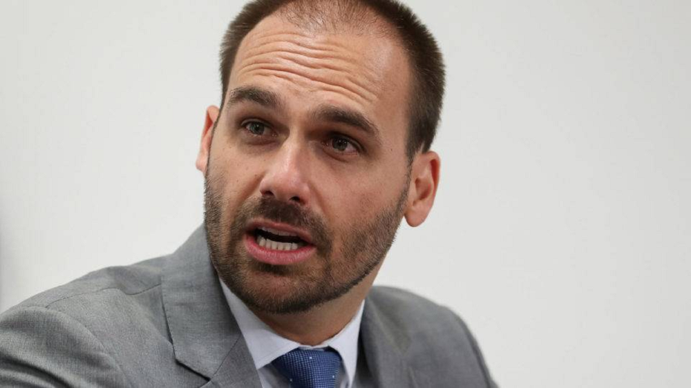 Eduardo Bolsonaro (PL-SP) falando, sério, sem olhar para a câmera, em close